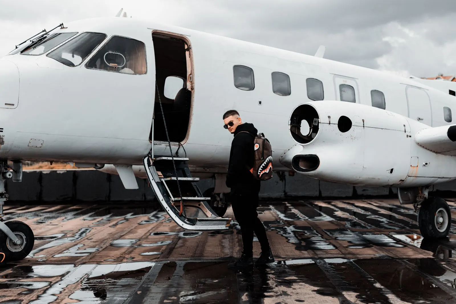 A first-class SUV positioned beside a business jet on the ramp at a private-aviation terminal