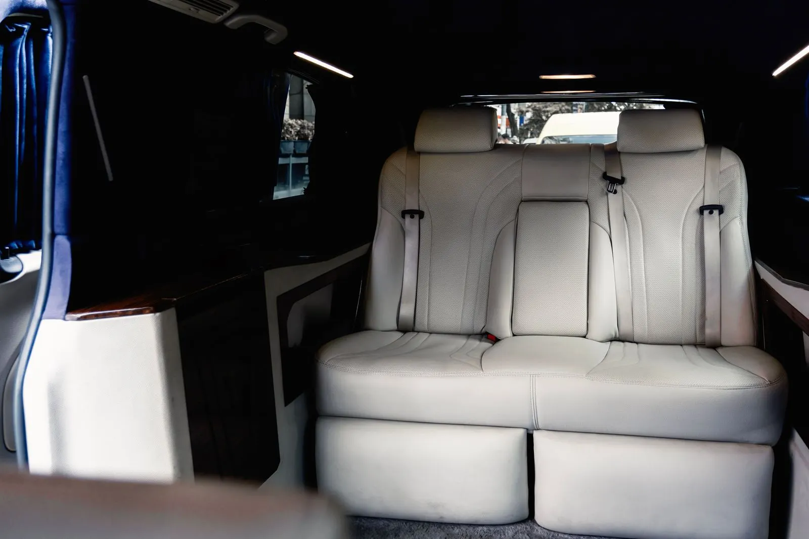 Rear cabin of a flagship sedan with reclining seats, tablet and chilled water
