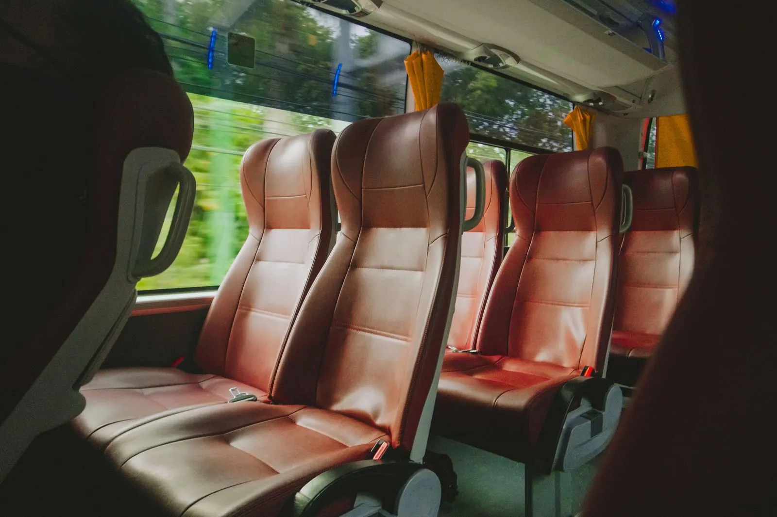 Interior of an executive Sprinter van with leather seats, a group boarding at an airport