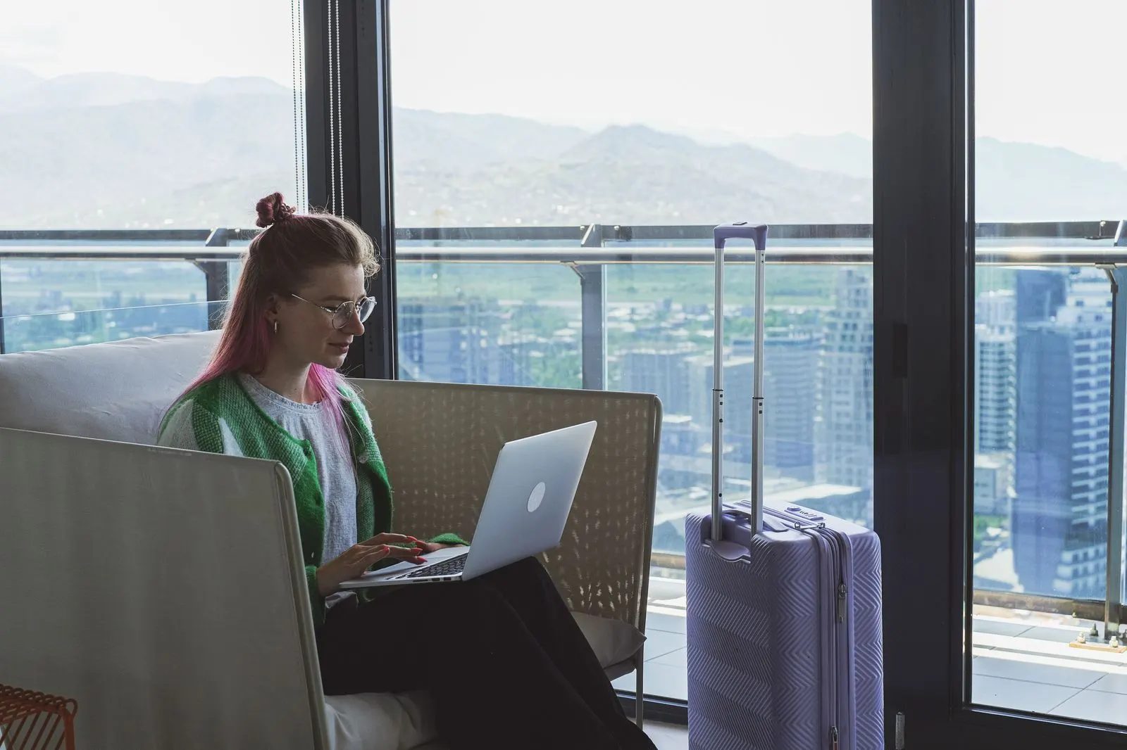 A traveller planning a trip on a laptop with a passport, a boarding pass and a chauffeur confirmation